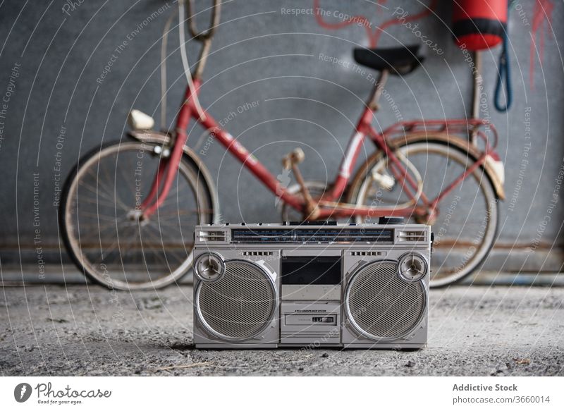 Retro Boombox gegen Fahrrad in der Garage Kassettenspieler einzelne Kassette altmodisch retro Beton Stock veraltet tragbar Nostalgie Grunge grau schäbig Wand