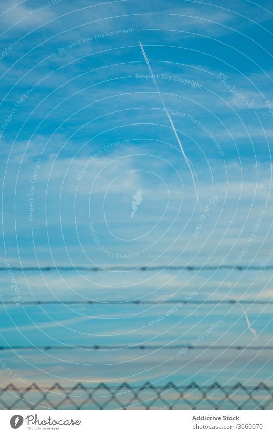 Flugzeugkondensstreifen am blauen Wolkenhimmel bei Tageslicht Kondensstreifen Blauer Himmel vertikal Linie Sicherheit Zaun wolkig idyllisch Landschaft