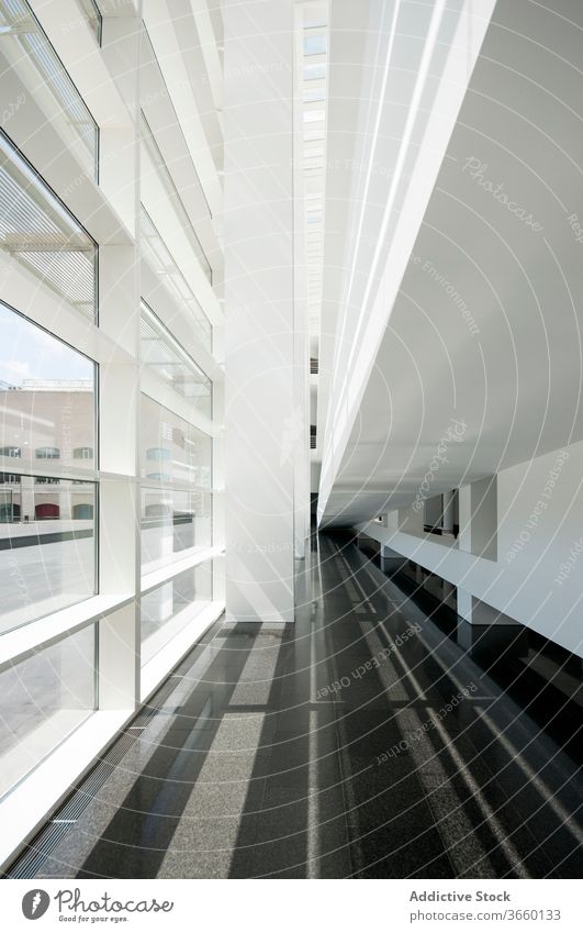 Modernes Gebäude mit symmetrischen Fenstern und dunklem Boden Architektur Gang Symmetrie Kontrast Stock Wand leer modern Stil Geometrie Sonnenlicht eng urban