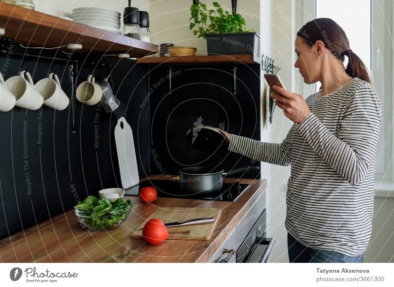 Frau telefoniert beim Kochen Essen zubereiten Küche Telefon heimwärts Lifestyle Lebensmittel Gesundheit Mahlzeit Haus Smartphone Mobile Beteiligung frisch