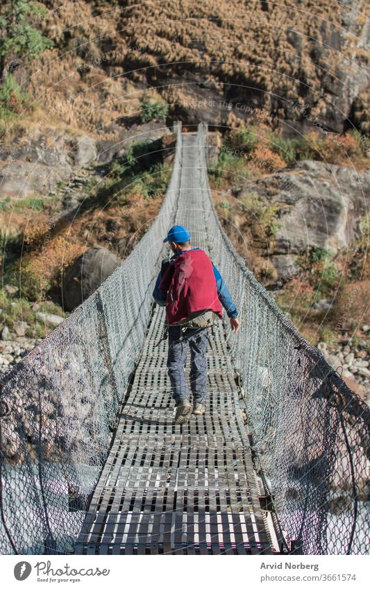 Abenteurer-Trekking über eine Hängebrücke, Annapurna-Rundweg, Nepal Aktivität Abenteuer entlang Annapurna-Kreislauf Rucksack Backpacker Brücke Buddhismus