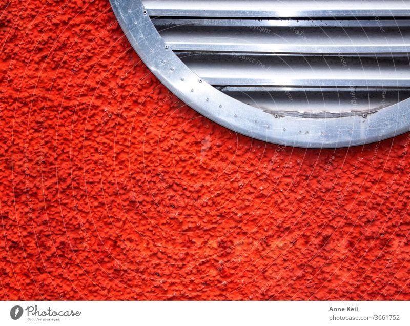 Knallige rot orangene Hauswand mit rundem Lüftungsgitter Fassade Außenaufnahme Wand Farbfoto Menschenleer Tag Mauer Rot Orange silber Gitter Metall