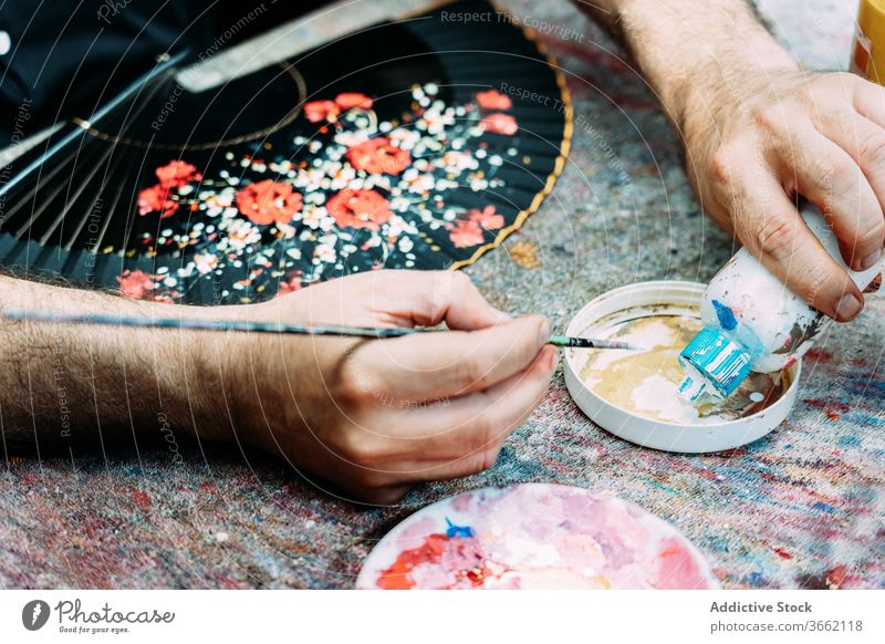 Scherenschnittkünstler gießt weiße Gouache in die Palette, während er Waver malt Künstler Farbe zeichnen Pinselblume Kunstwerk Handfächer Prozess geblümt Muster