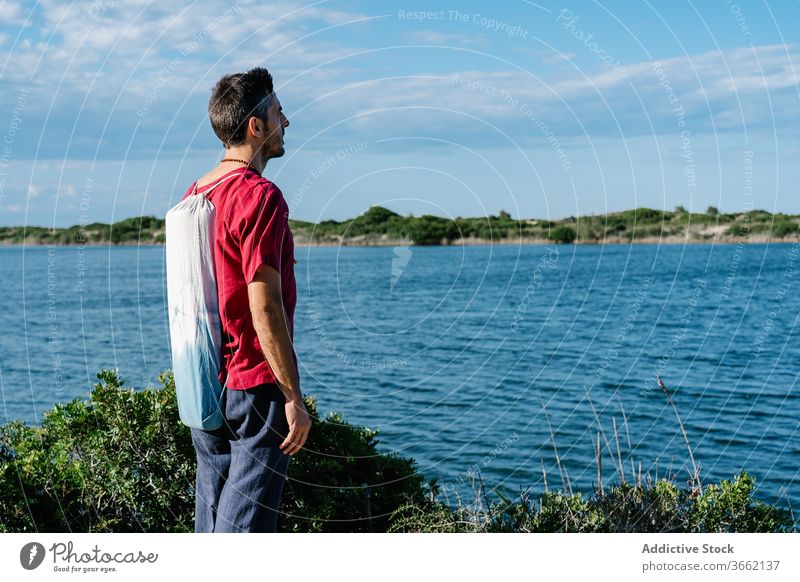Nachdenklicher junger Mann genießt Meereslandschaft vor blauem Himmel sich[Akk] entspannen Hügel MEER bewundern Windstille friedlich Erholung Natur Harmonie