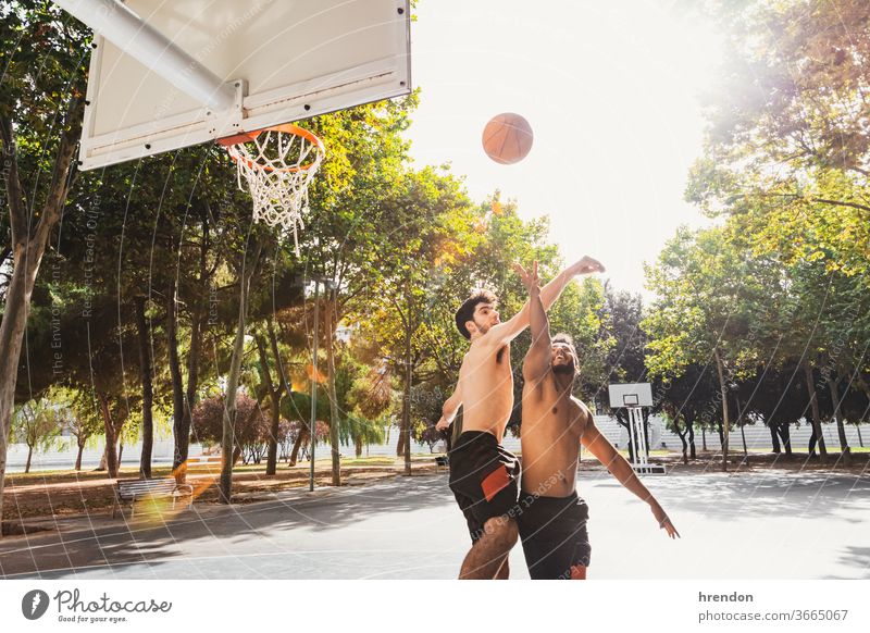 zwei junge Männer spielen Basketball im Freien Sport Konkurrenz Ball Spiel sportlich wettbewerbsfähig Spielen Übung männlich trainiert. anstrengen Hobby