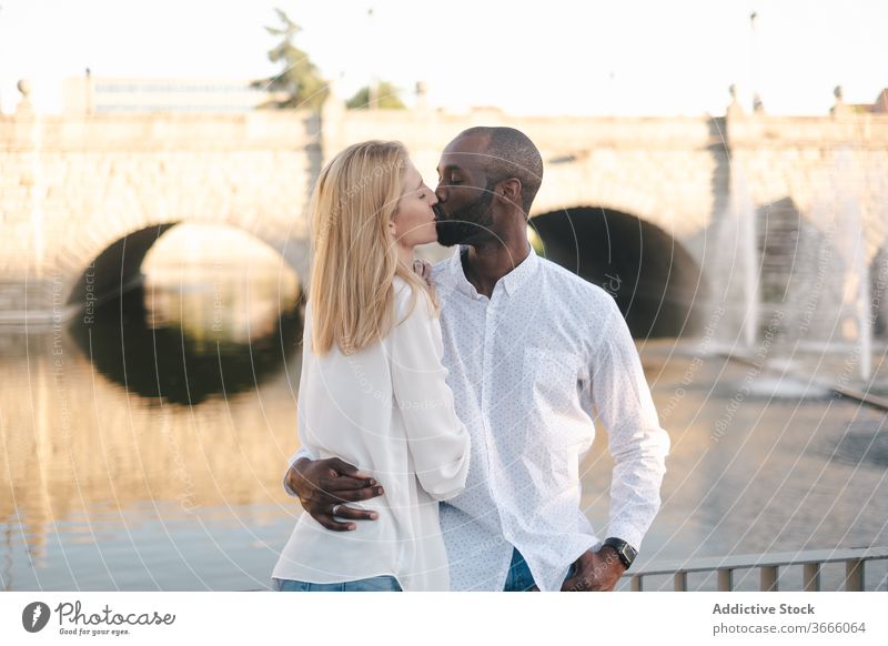 Zufriedenes multiethnisches Paar, das sich auf der Straße umarmt und verbindet Kuss Umarmen Streicheln kuscheln Partnerschaft Romantik Liebe Angebot Inhalt