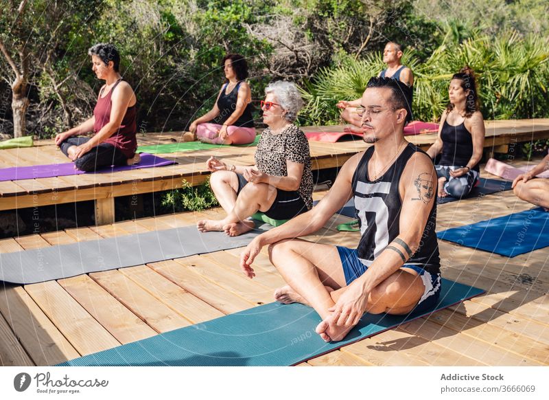Multiethnische Menschen, die in den Sommerferien Yoga praktizieren meditieren Lotus-Pose padmasana üben tropisch Resort sich[Akk] entspannen Harmonie Wellness