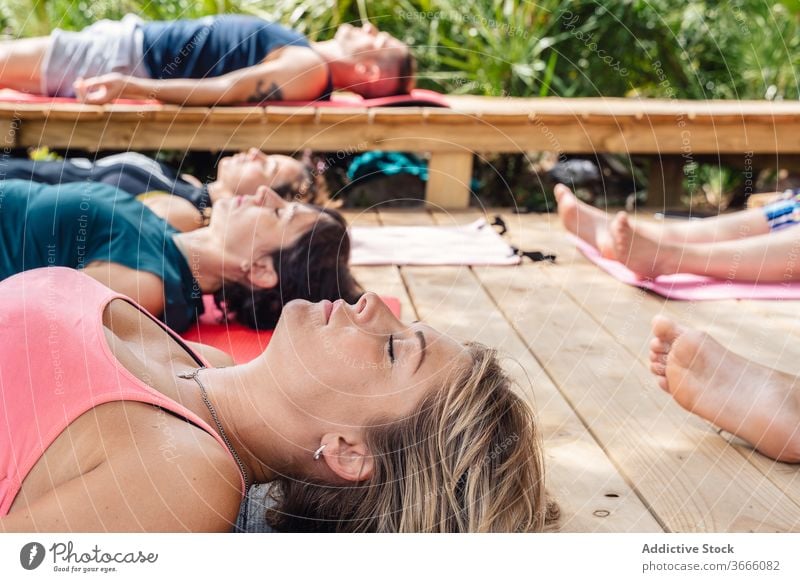 Yogalehrerin meditiert in Savasana-Position während des Unterrichts mit Ausbilder Frau Menschen Leiche savasana Lotus-Pose Lager meditieren sich[Akk] entspannen