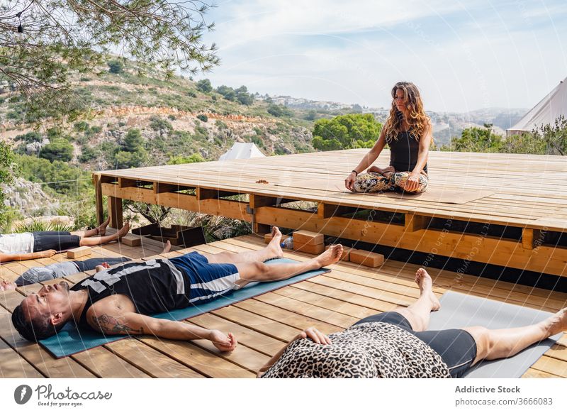 Gruppe von Yogaausbildern meditiert in Savasana-Position während des Unterrichts mit Ausbilder Menschen Leiche savasana Lotus-Pose Lager meditieren Erholung