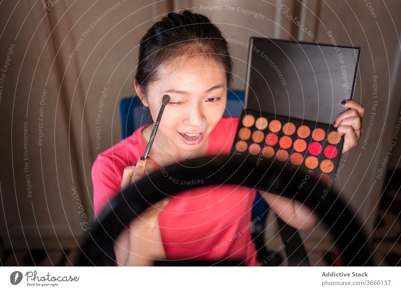 Schönheitsbloggerin mit Make-up-Palette nimmt Video auf vlog Blogger Frau Kosmetik Aufzeichnen manifestieren positiv jung asiatisch ethnisch zeigen Lächeln