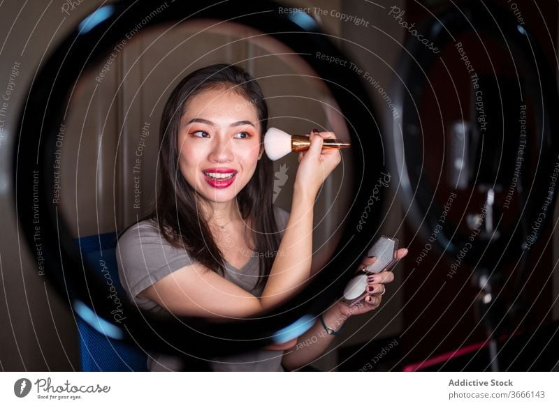 Schönheitsbloggerin, die sich während des Shootings schminkt vlog Blogger Frau Make-up bewerben Kosmetik Fundament Aufzeichnen Video jung asiatisch ethnisch