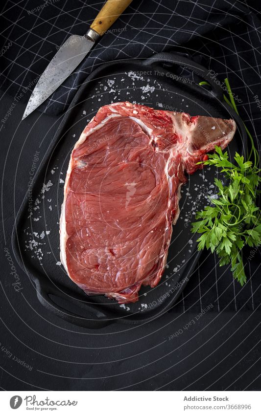 Rohes T-Bone Beefsteak mit rotem Pfeffer, Tomate, rosa Pfeffer und p Rindfleisch roh Steak Fleisch Vorbereitung Essen zubereiten Lebensmittel T-Knochen