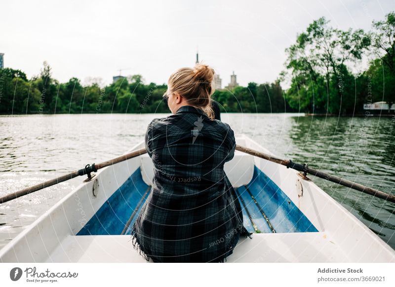Anonyme Frau rudert im Boot auf dem See Rudern positiv sculling Natur Aktivität friedlich Windstille sich[Akk] entspannen Sommer Freizeit Lifestyle reisen schön