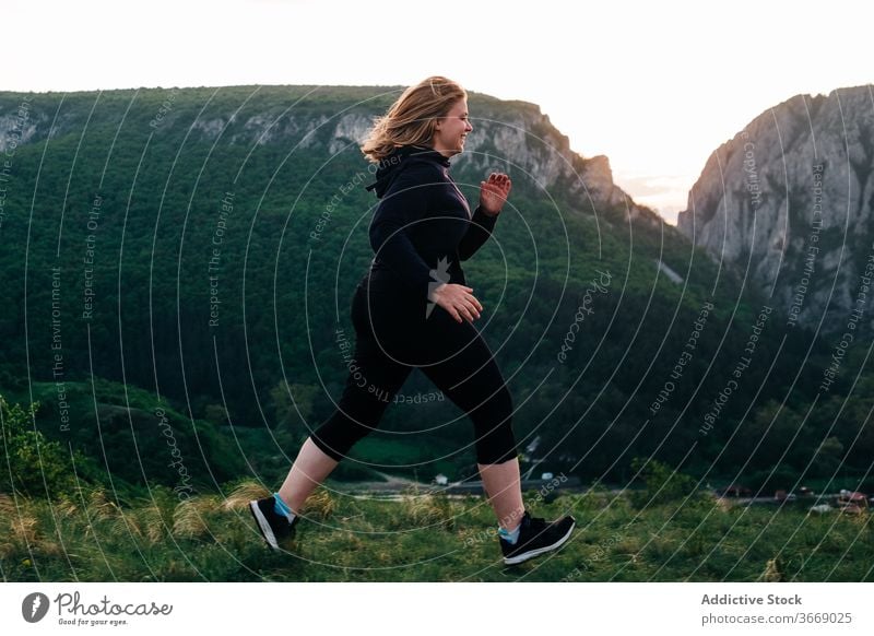 Sportlerin joggt bei Sonnenuntergang in den Bergen laufen Berge u. Gebirge Frau joggen Abend Hochland mollig Training Transsilvanien Rumänien heiliger george