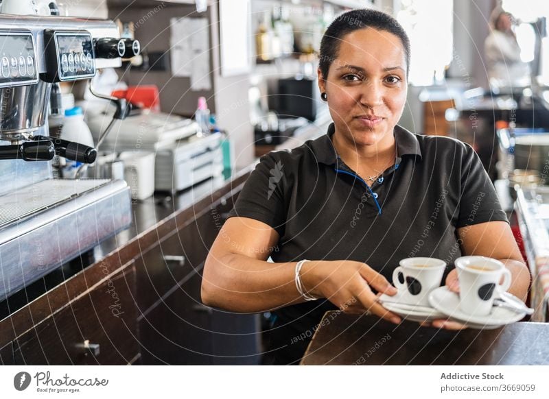 Ethnische Barista-Frau mit Kaffee in der Bar Dienst Personal Beruf Tasse dienen Kleinunternehmen Kellnerin Mitarbeiter trinken Job Kaffeehaus selbstbewusst