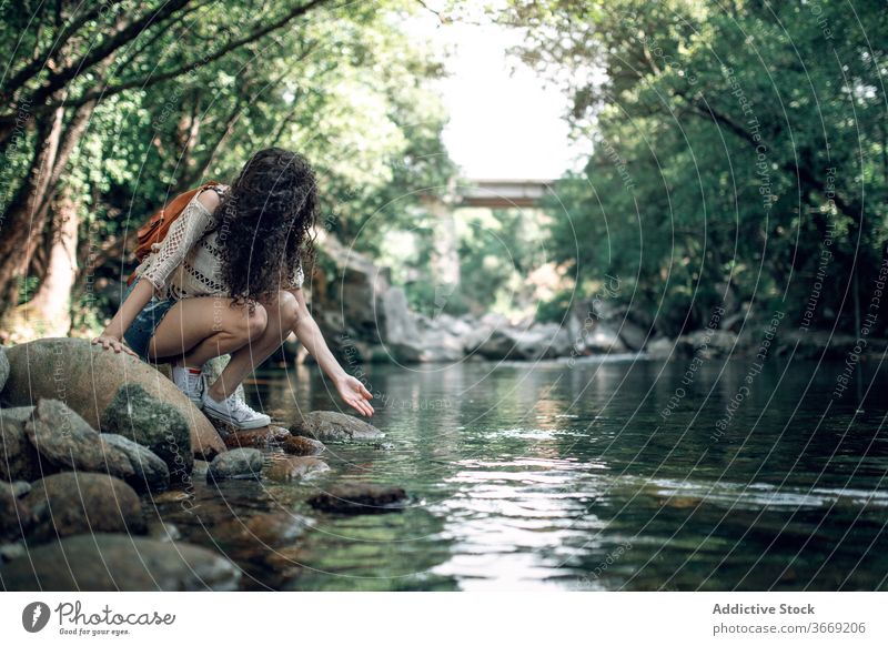 Reisende Frau in der Nähe von Fluss im Wald reisen Tourist Sommer Urlaub Wasser Feiertag Gelassenheit Windstille Natur Stein Ufer Wochenende Harmonie ruhig