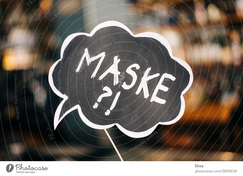 Ein Schild mit der Aufschrift "Maske?!" als Ermahnung an Gäste, die Maskenpflicht zu beachten. Gastronomie. Corona. Frage Mundschutz Fragezeichen Umgang
