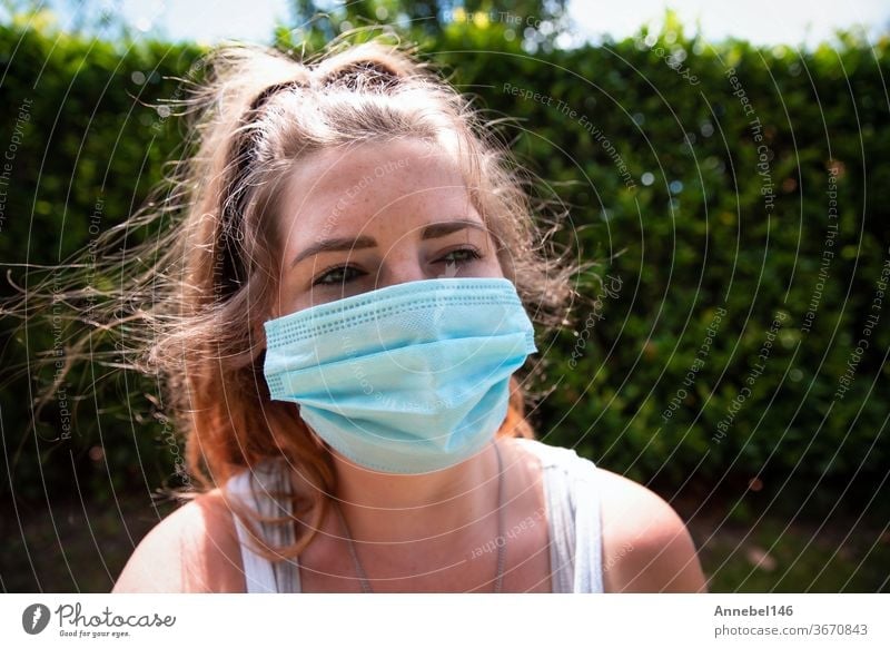 Junge Frau mit Gesichtsmaske, Sicherheitsmaske für COVID-19, Coronavirus. Porträt eines erwachsenen Mädchens im Freien. Konzept für Grippe oder Coronavirus-Infektion