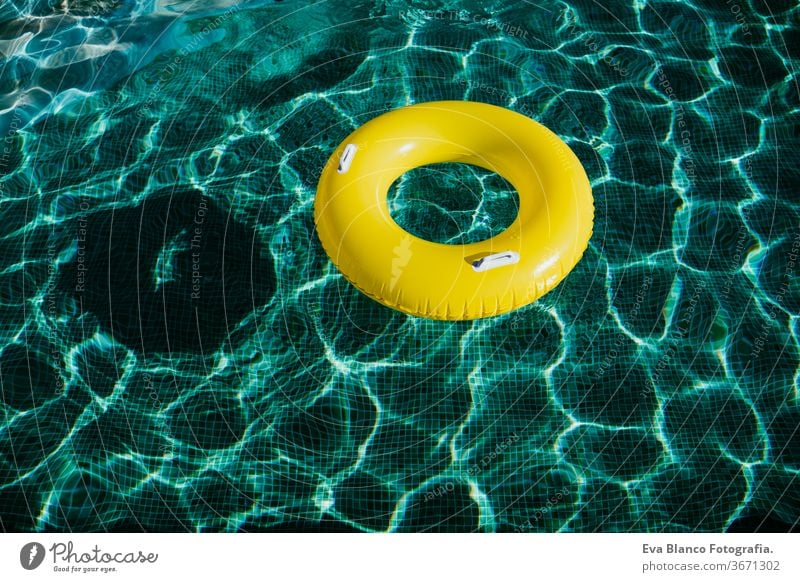 gelbe aufblasbare Donuts, die in einem Schwimmbecken schwimmen. Niemand. Konzept der Sommerzeit Schwimmbad niemand Blauwasser Spielzeug Ring Wasser Bewahrer