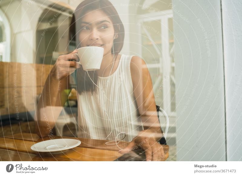 Junge Frau trinkt im Café eine Tasse Kaffee. jung Porträt Latein Kaffeehaus im Freien brünett Freizeit selbstbewusst Lifestyle Erfrischung Selbstvertrauen