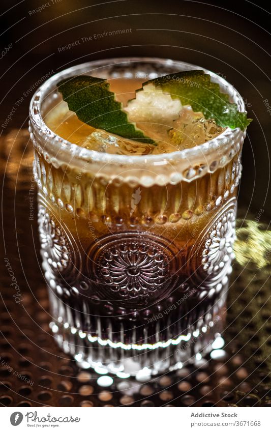 Alkoholisches Getränk mit Limettenschalen Cocktail Bar Kalk Eis sich[Akk] schälen Würfel Locken kalt Tasse Glas Restaurant dunkel Tisch trinken Erfrischung Pub