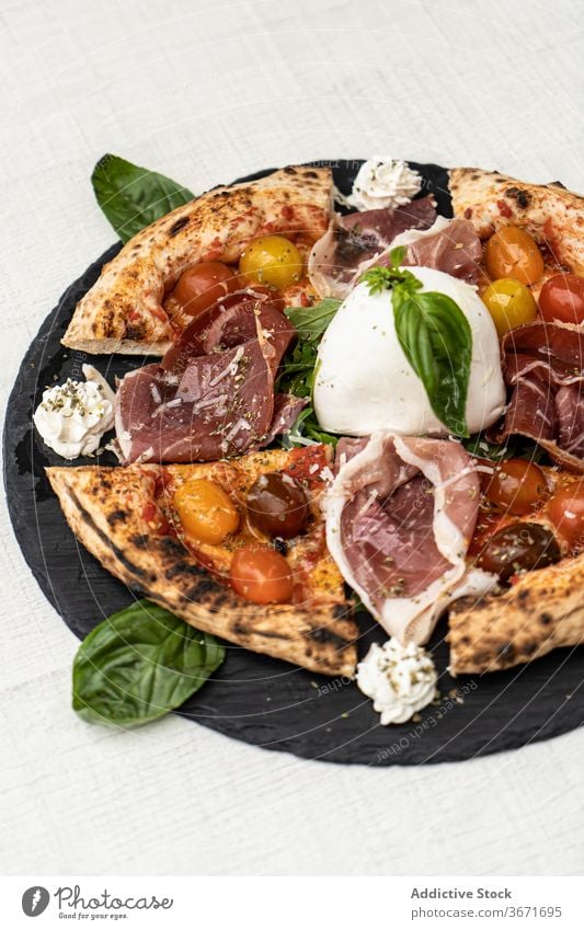 Leckere Pizza mit geschnittenen Tomaten, Prosciutto und Mozzarella Schinken Scheibe Basilikum lecker Italienisch Lebensmittel Feinschmecker Speise geschmackvoll