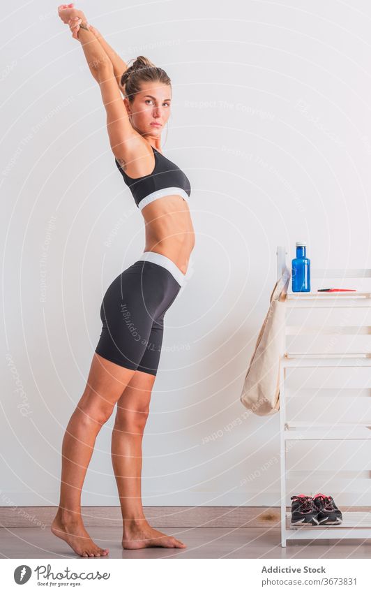 Schlanke Frau streckt die Arme vor dem Training Aufwärmen Dehnung Waffen Fitnessstudio selbstbewusst beweglich schlank passen Athlet Barfuß modern Übung