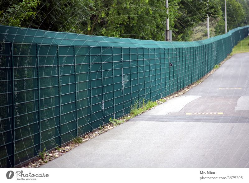 Ein langer grüner Zaun Barriere Sicherheit Absperrung gefangen bedrohlich Grenze Freiheit Schutz Flucht Ausgrenzen Gefangenschaft Verbote eingesperrt