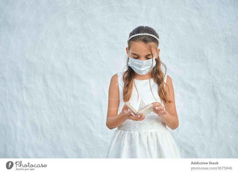 Mädchen mit Schutzmaske bei ihrer Erstkommunion Coronavirus Kommunion Mundschutz Kind christian Prävention Corona-Virus unschuldig religiös Religion Frau Kleid