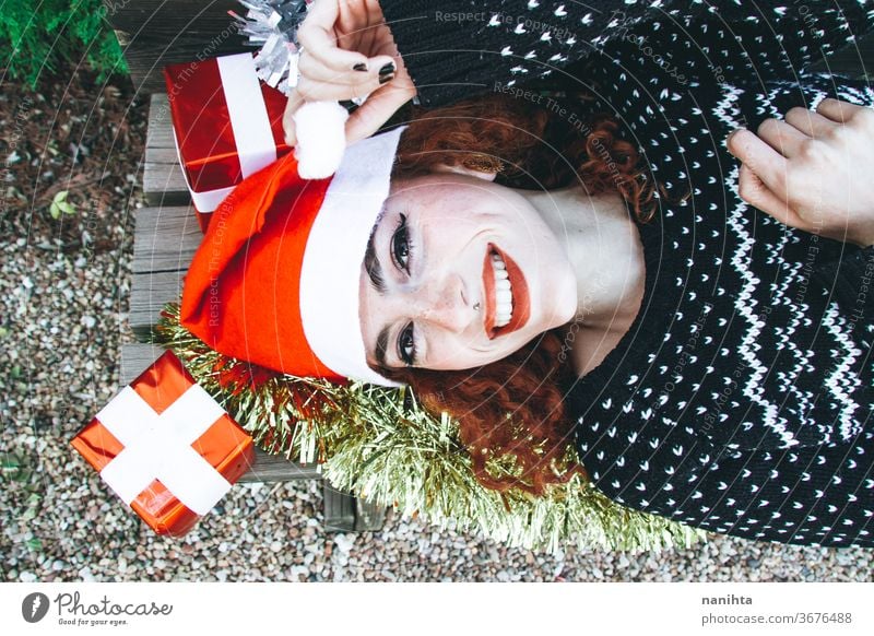 Junge rothaarige Frau im weihnachtlichen Gewand auf einer Bank liegend Rotschopf Weihnachten Feiertage Geschenk Menschen wirklich hübsch jung Jugend Glück