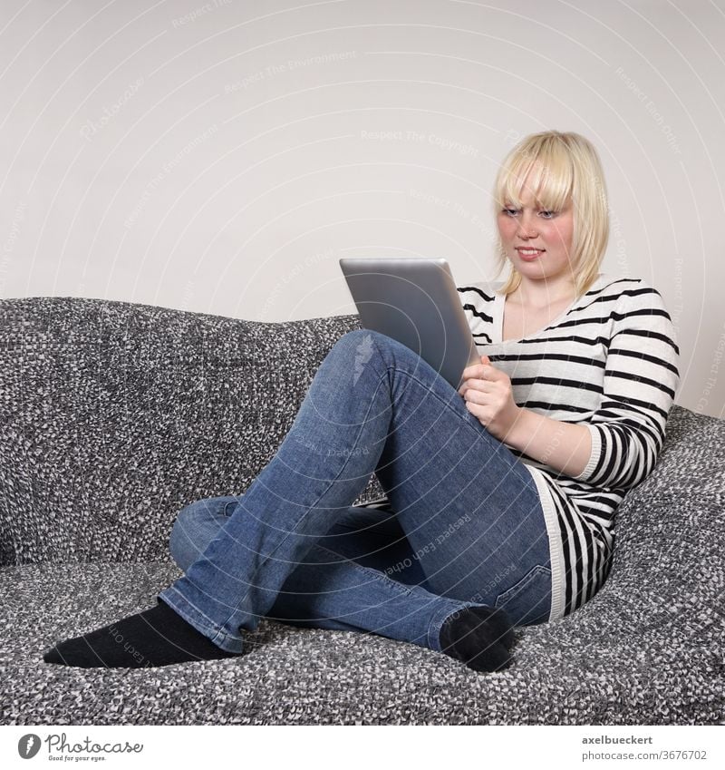 junge Frau mit Tablet Computer auf der Couch Sofa tablet zuhause Homeschooling E-Learning E-Book lesen Technik & Technologie Mädchen Entertainment pc Schüler
