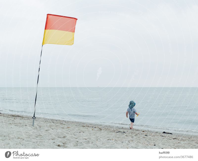 Rettungsfahne am Strand der kleine Junge will ins Wasser Kleinkind strandbad Rettungsschwimmer Badezone Schwimmbad Rettungsboje Lebensretter Sicherheit Nordsee