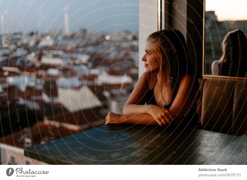 Junge Frau genießt das Stadtbild vom Café aus Dachterrasse Großstadt Fenster Abend Madrid Sonnenuntergang gemütlich urban Spanien Glaswand Komfort