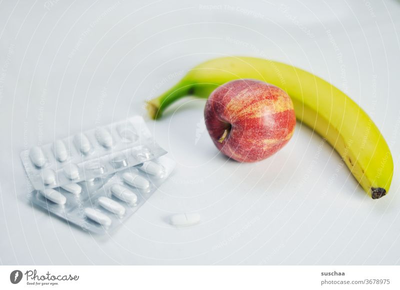 gesunde ernährung vs. nahrungsergänzungsmittel .. apfel, banane und tabletten Apfel Banane Tabletten Frucht Gesundheit Lebensmittel Vegetarische Ernährung