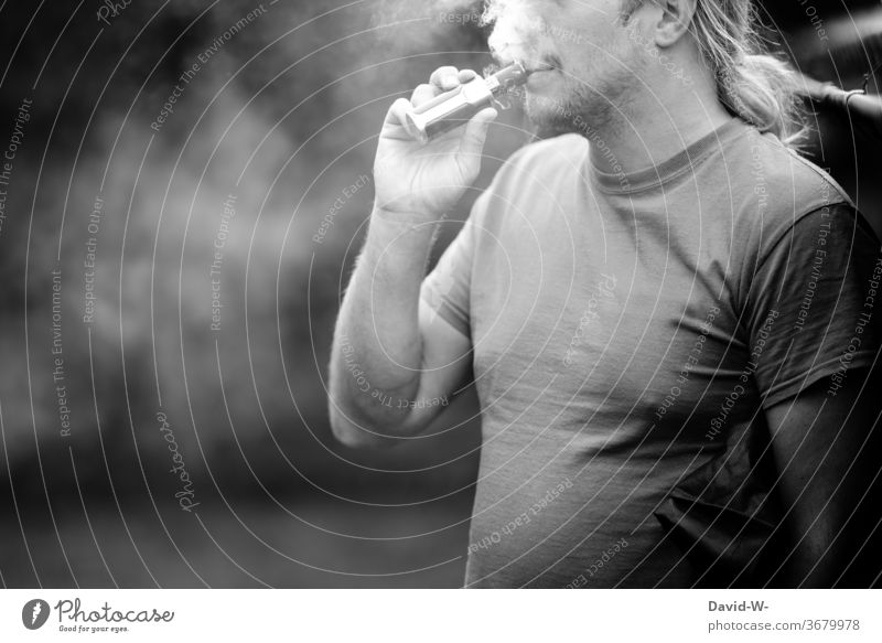 Mann zieht an einer E-Zigarette e-zigarette Zigarrete elektrisch elektronisch Abhängigkeit Drogen sucht suchtpotential süchtig abhängig sein Schwarzweißfoto