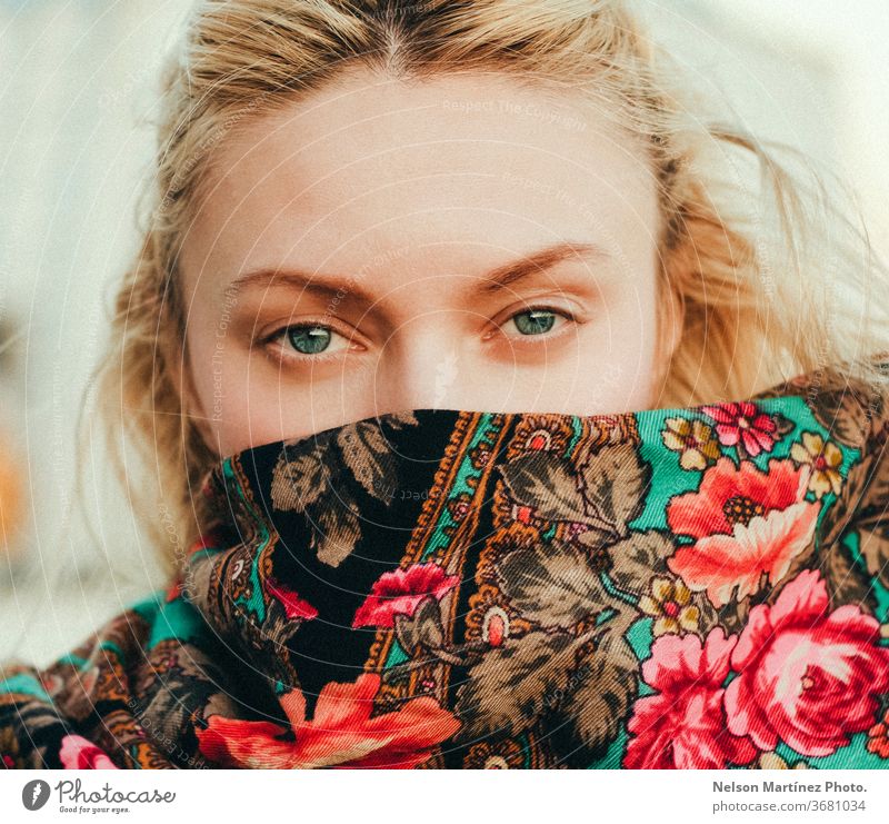 Porträt einer kausalen Blondine.  Sie blickt direkt in die Kamera, die mit einem Schal mit Blumenmuster bedeckt ist. blond Kaukasier Frau schön hübsch Gesicht