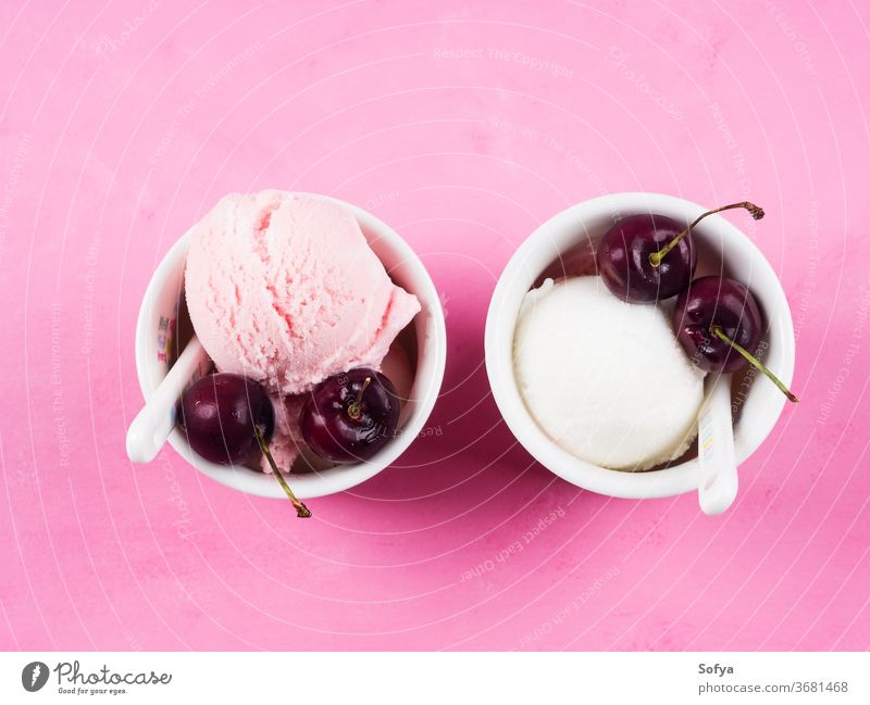 Zwei Eisbecher mit Kirschen auf rosa Erdbeeren Speiseeis Baggerlöffel Ball gelato rot Beeren Joghurt Sommer süß Tasse Sahne Frucht Versuchung Belag Lebensmittel