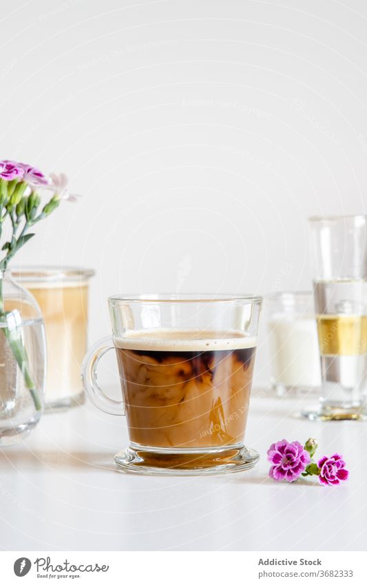 Glastasse mit kaltem Kaffee und Milch Latte melken Eis Tasse trinken frisch mischen lecker geschmackvoll Blume Morgen Frühstück Geschmack schäumen Sahne Getränk