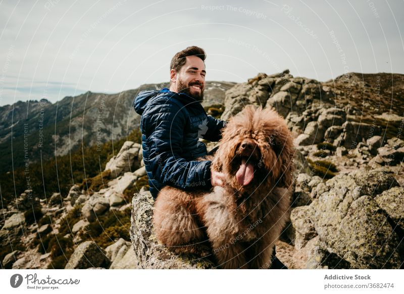 Männlicher Wanderer mit Hund in den Bergen Mann Berge u. Gebirge ruhen Ausflug Himmel Lächeln Glück bedeckt puerto de la morcuera Spanien männlich Stein