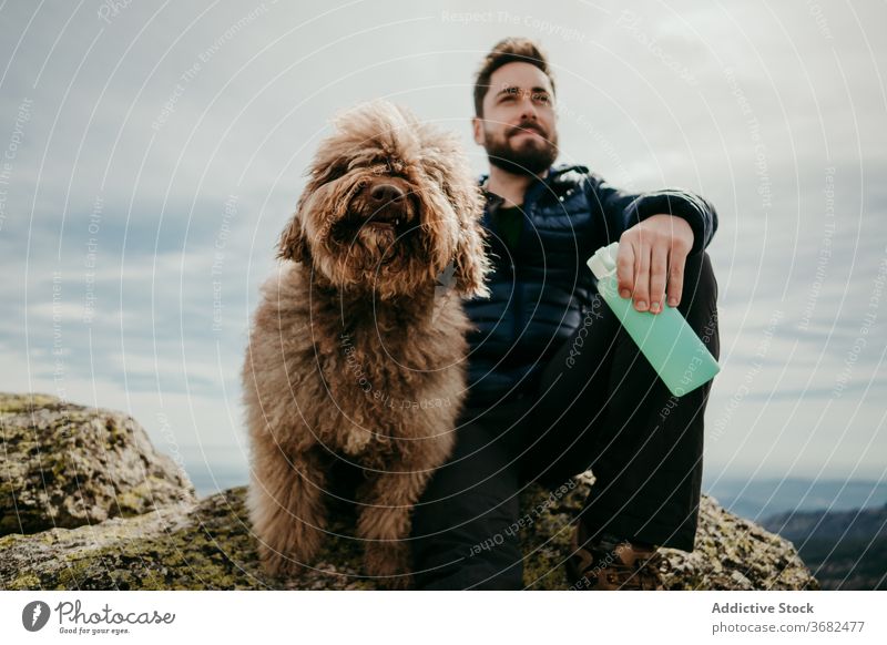 Männlicher Wanderer mit Hund in den Bergen Mann Berge u. Gebirge ruhen Ausflug Himmel bedeckt Flasche puerto de la morcuera Spanien männlich Wasser Stein