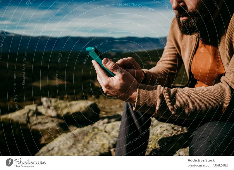 Bärtiger Wanderer benutzt Smartphone in den Bergen Mann benutzend Berge u. Gebirge Landschaft Himmel wolkig ruhen puerto de la morcuera Spanien männlich reisen