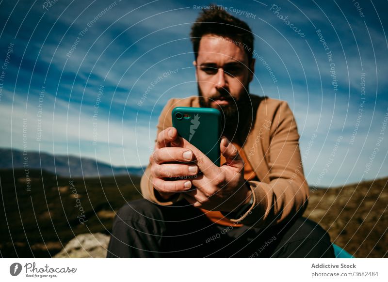 Bärtiger Wanderer benutzt Smartphone in den Bergen Mann benutzend Berge u. Gebirge Landschaft Himmel wolkig ruhen puerto de la morcuera Spanien männlich reisen