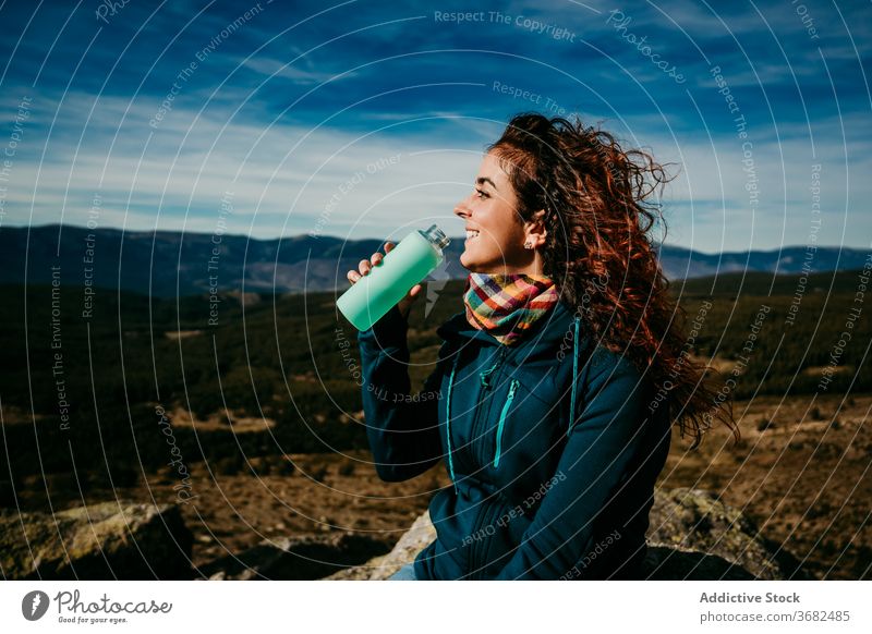 Glückliche weibliche Reisende trinkt Wasser in den Bergen Frau trinken Berge u. Gebirge reisen Lächeln Flasche Landschaft puerto de la morcuera Spanien heiter