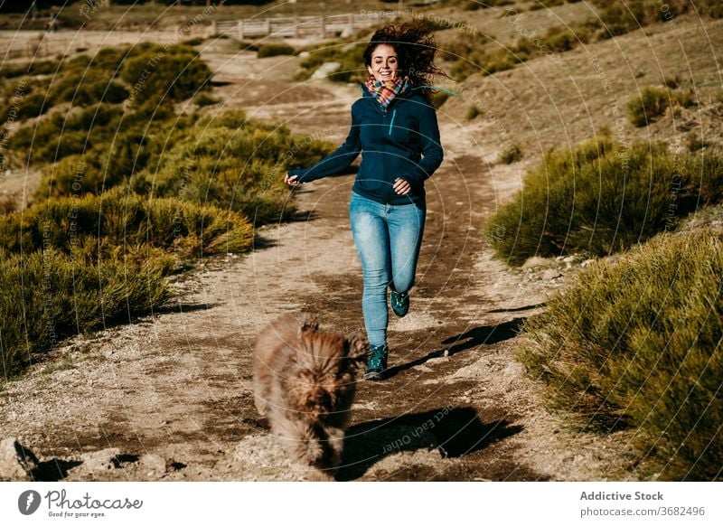 Frau und Hund laufen auf dem Lande Weg Landschaft Spaß folgen Wochenende puerto de la morcuera Spanien Labradoodle sonnig tagsüber Glück Lächeln heiter