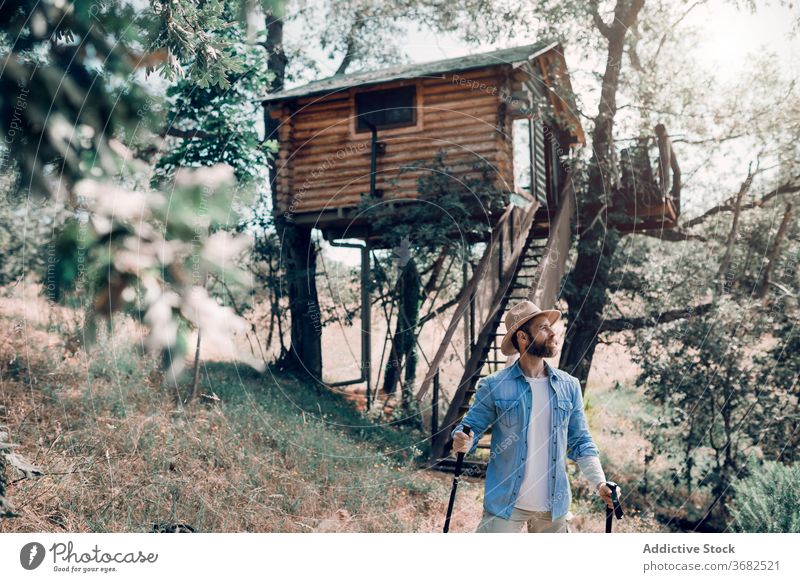 Reisender Mann mit Trekkingstöcken im Wald Mast Wanderung Tourist Natur Urlaub Sommer männlich Baum Wälder grün Hütte sorgenfrei reisen Tourismus Haus Ausflug