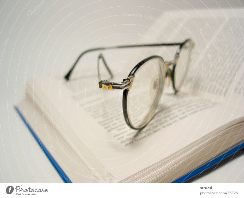 Brille auf Buch lernen Bibliothek lesen genießen Literatur Dinge Buch. lesen Seite Linse Buchseite blau-weiß nachdenklich Bücherei Freizeit & Hobby schmökern