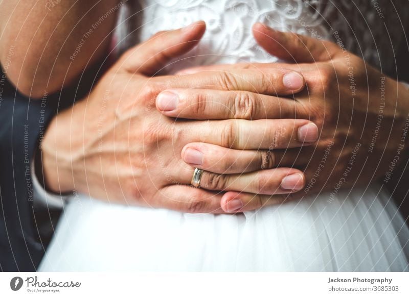 Nahaufnahme der Handflächen des Bräutigams bei der Umarmung der Braut. striegeln Ring Hochzeit Umarmen abschließen Taille umarmend Detailaufnahme Finger Konzept