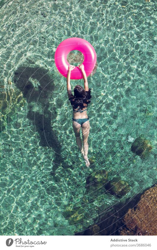 Frau schwimmt im Wasser mit Ring schwimmen Urlaub Resort Sommer Badebekleidung durchsichtig aufblasbar Tube sonnig tagsüber sich[Akk] entspannen Erholung ruhen