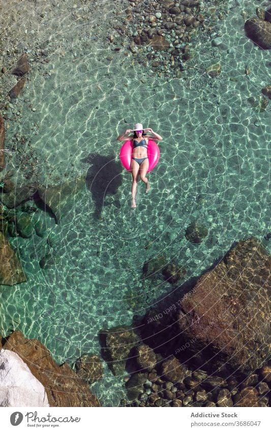 Frau schwimmt im Wasser mit Ring schwimmen Urlaub Resort Sommer Badebekleidung Sonnenbrille durchsichtig aufblasbar Tube sonnig tagsüber sich[Akk] entspannen