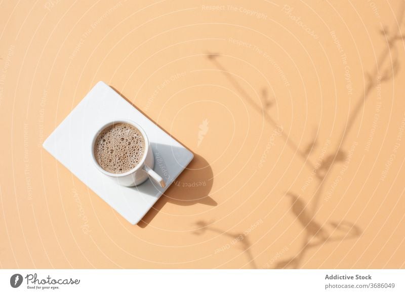 Tasse Kaffee auf beigem Tisch trinken Aroma frisch heiß Becher Getränk natürlich Morgen Koffein Schatten Sonnenlicht Pflanze Ast Frühstück lecker Energie